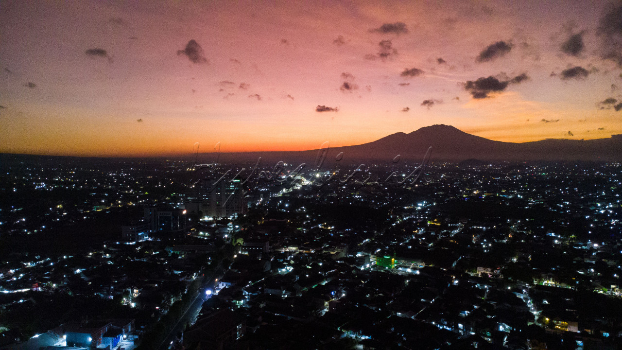Nampak pemandangan Kota Jember di pagi hari saat matahari terbit dengan latar belakang Gunung Raung merupakan salah satu gunung aktif di Indonesia yang berada di kabupaten Banyuwangi Jawa Timur.