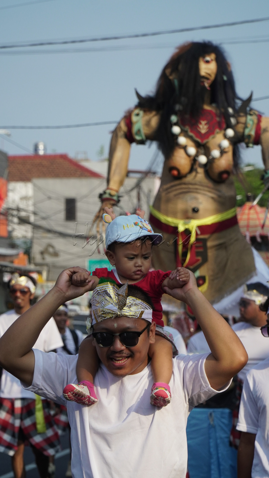 Seorang bapak menggendong anaknya ikut memeriahkan&nbsp; karnaval kemerdekaan RI ke 79 di kelurahan Dinoyo kota Malang. Karnaval ini menampilkan beragam seni budaya Indonesia yang diwakili masing-masing RT &amp; RW.&nbsp;
