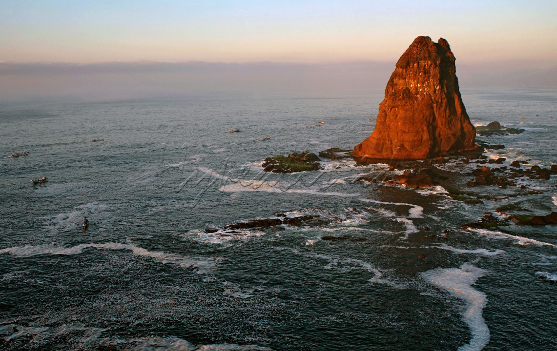 Pesona Gunung Kajang dan aktivitas para nelayan saat pagi hari di kawasan Tanjung Papuma yang ada di Desa Lojejer, Kecamatan Wuluhan, Jember Jawa Timur. Gunung Kajang merupakan gugusan karang sebelah selatan Tanjung Papuma juga terlihat lebih jelas dari Siti Hinggil. Salah satu karang palig besar yang tegak berdiri kokok dengan latar belakang lautan lepas.