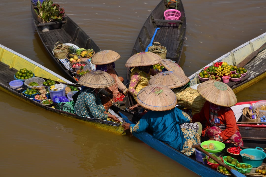 Pedagang pasar terapung berkumpul untuk melakukan atraksi diatas perahu guna menarik perhatian wisatawan&nbsp;