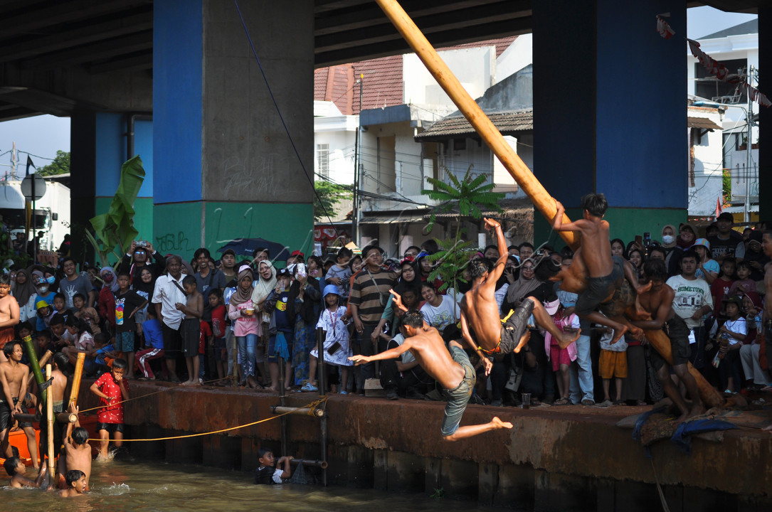 Peserta Panjat pinang di bantaran kalimalang, Jakarta Timur, dalam rangka perayaan HUT RI ke 79