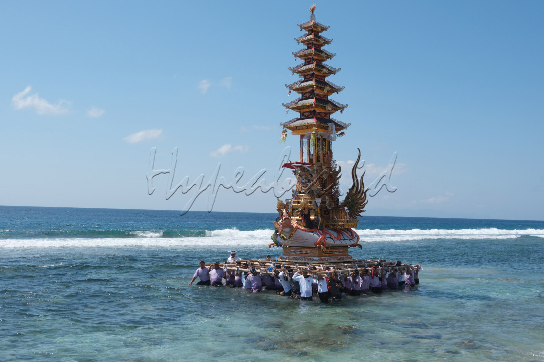 Sejumlah umat Hindu mengarak tempat pembakaran jenazah saat melintasi pantai pada upacara ngaben massal di Desa Adat Karangsari, Nusa Penida, Klungkung, Bali, Kamis (18/7/2024). Upacara ngaben massal tersebut digelar setiap lima tahun sekali dengan berjalan melintasi pantai.