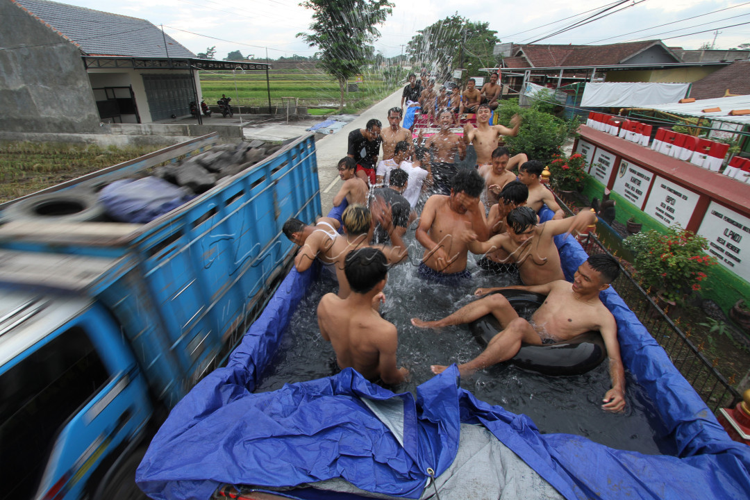 Warga dengan menggunakan truk pasir mendesain truk tersebut untuk dijadikan kolam yang digunakan untuk berenang dalam tradisi Padusan di Klaten, Jawa Tengah, Senin (11/3/2024). Padusan sebagai tradisi &nbsp;untuk membersihkan diri di sumber mata air sebagai kesiapan diri untuk menyambut bulan Ramadhan.