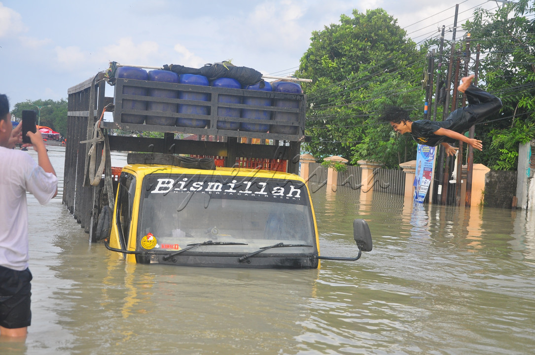 Bismillah&nbsp;<br />
<br />
Seorang pria melompat dari truk saat banjir menenggelamkan jalan raya nasional pantura Kabupaten Demak, Jateng, Februari 2024 lalu. Kendati bencana melanda, masyarakat tetap tegar dan terus berdoa agar semuanya kembali pulih.<br />
<br />
&nbsp;