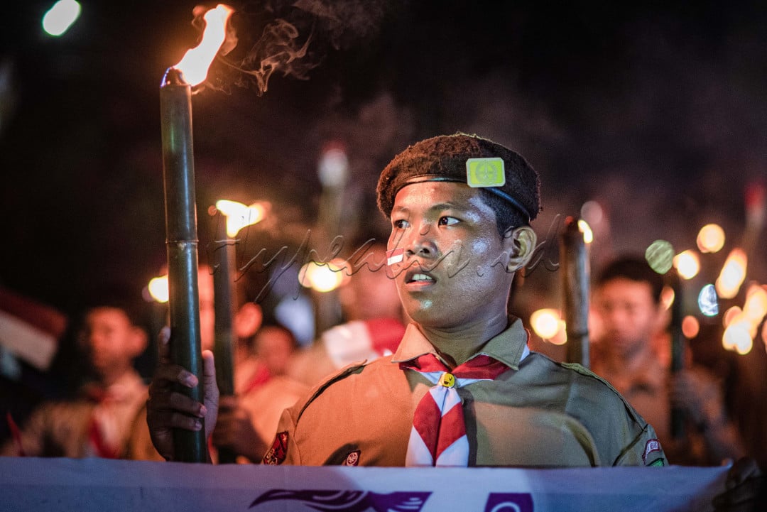Dengan Obor ditangan membuat seorang peserta pawai menatap siaga kesekelilingnya, agar ketika terjadi hal yang tidak diinginkan, bisa segera untuk diatasi&nbsp;