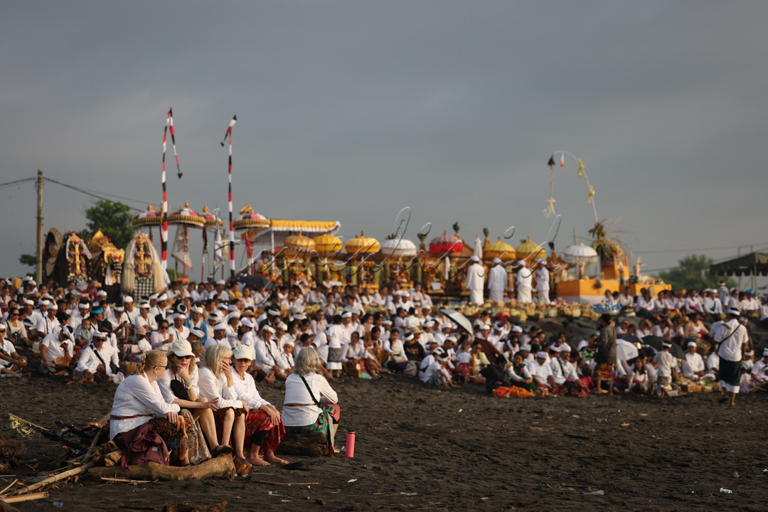 Warga Negara Asing menyaksikan umat ??Hindu mengikuti upacara pensucian diri yang disebut Melasti, untuk menyambut hari raya Nyepi di Pantai Lembeng, Bali, Indonesia, Jumat 8 Maret 2024.
