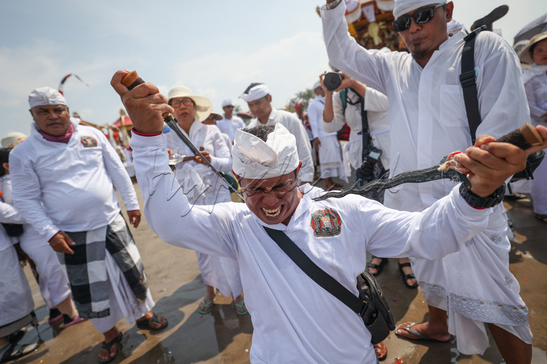 Umat ??Hindu menusukkan keris ke tubuh saat upacara pensucian diri yang disebut Melasti, untuk menyambut hari raya Nyepi di Pantai Petitenget, Bali, Indonesia, Jumat 8 Maret 2024.