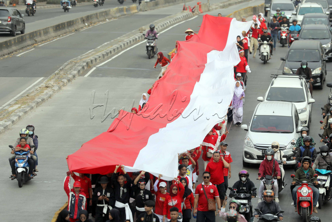 Warga saat melakukan parade bendera merah putih di Jalan Daan Mogot Kawasan Rawa Buaya, Jakarta Barat, Sabtu (17/8/2024).