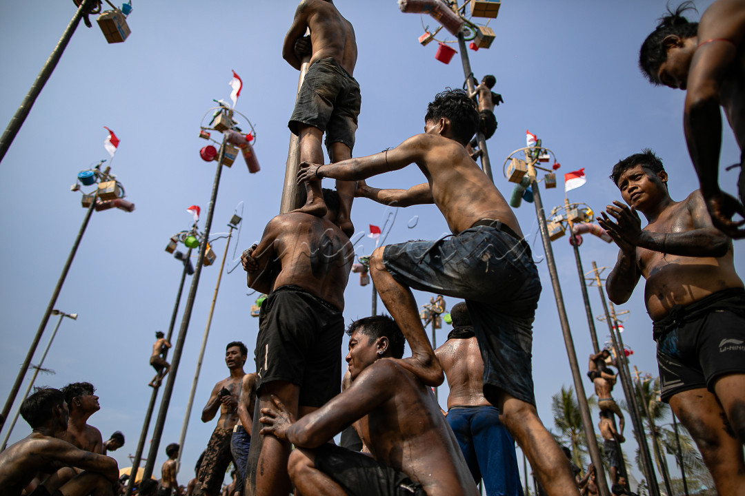 Para peserta berusaha mencapai puncak tiang yang dilumuri minyak untuk mendapatkan hadiah dalam kompetisi panjat pinang di Pantai Festival Ancol, Jakarta Utara, Sabtu (17/8/2024).&nbsp;Sebanyak 51 batang pinang dengan beragam hadiah menarik seperti peralatan rumah tangga dan sepeda itu disediakan dalam lomba yang diikuti ratusan warga&nbsp;untuk memeriahkan momen Hari Ulang Tahun (HUT) ke-79 Republik Indonesia yang jatuh pada tanggal 17 Agustus 2024.