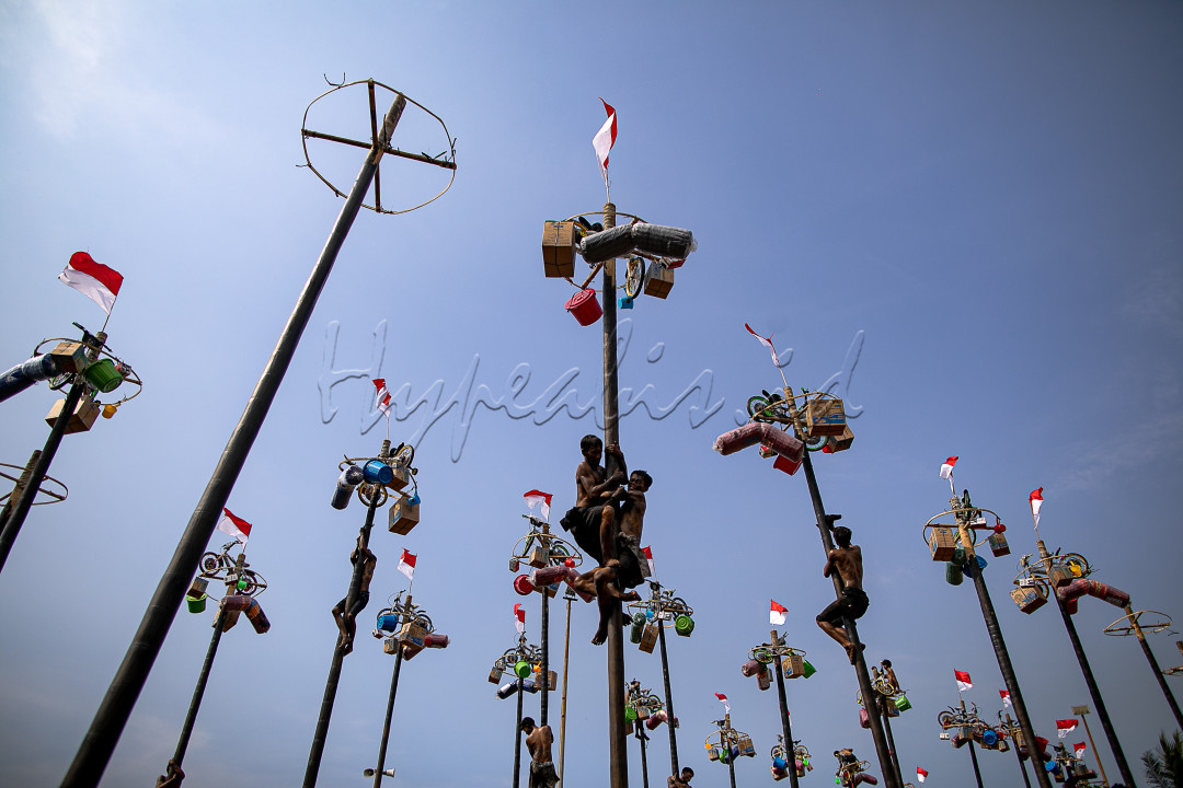 Para peserta berusaha mencapai puncak tiang yang dilumuri minyak untuk mendapatkan hadiah dalam kompetisi panjat pinang di Pantai Festival Ancol, Jakarta Utara, Sabtu (17/8/2024).&nbsp;Sebanyak 51 batang pinang dengan beragam hadiah menarik seperti peralatan rumah tangga dan sepeda itu disediakan dalam lomba yang diikuti ratusan warga&nbsp;untuk memeriahkan momen Hari Ulang Tahun (HUT) ke-79 Republik Indonesia yang jatuh pada tanggal 17 Agustus 2024.