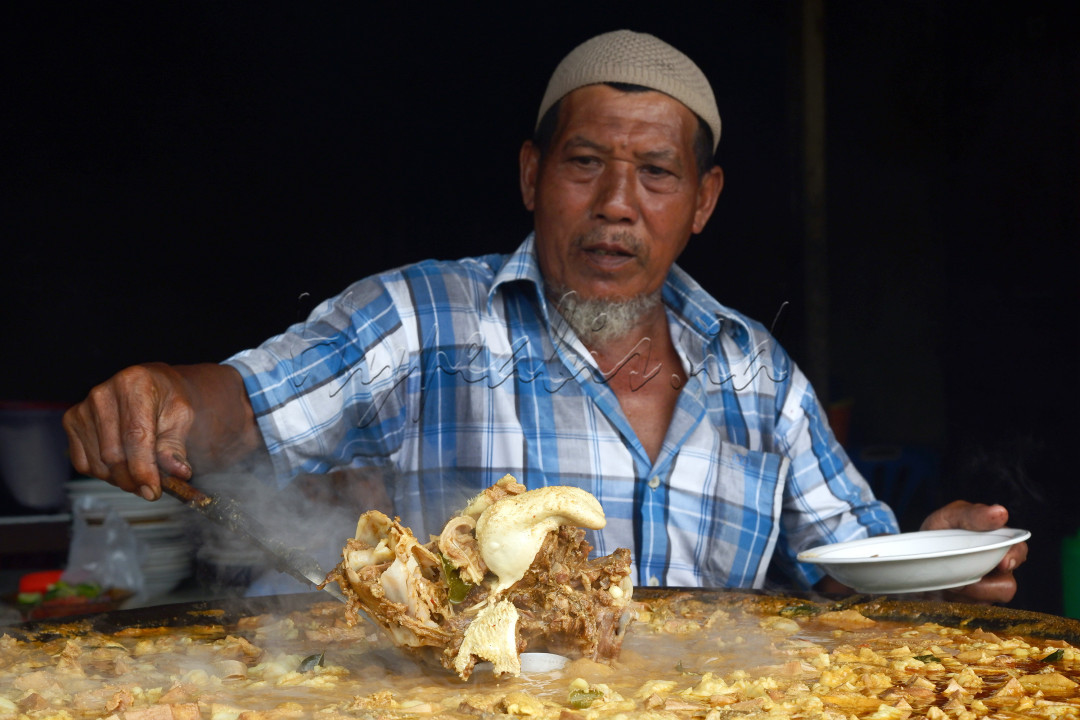 Seorang penjual kuang beulangong, masakan khas Aceh yang berupa Gulai Daging sedang menyiapkan masakannya di warung usaha tempatnya di Sibreh, Aceh Besar pada (12/06/2024)