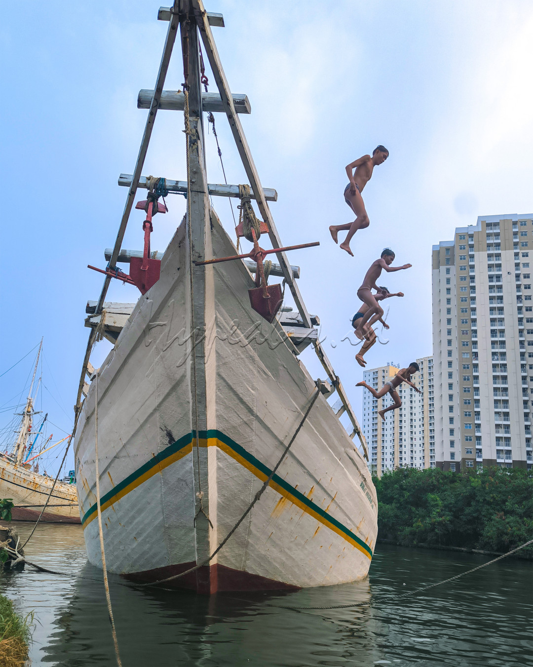 terlihat mpat orang anak pesisir aksi melompat dari atas perahu&nbsp; pelabuhan sunda kelapa jakarta&nbsp;