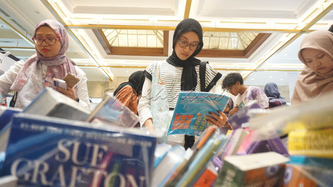 Pengunjung membaca buku-buku yang dipajang di Indonesia International Book Fair (IIBF) 2024 di JCC, Jakarta, Kamis (26/9/2024). IIBF merupakan pameran tahunan perdagangan penerbitan buku yang diselenggarakan oleh Ikatan Penerbit Indonesia (IKAPI).