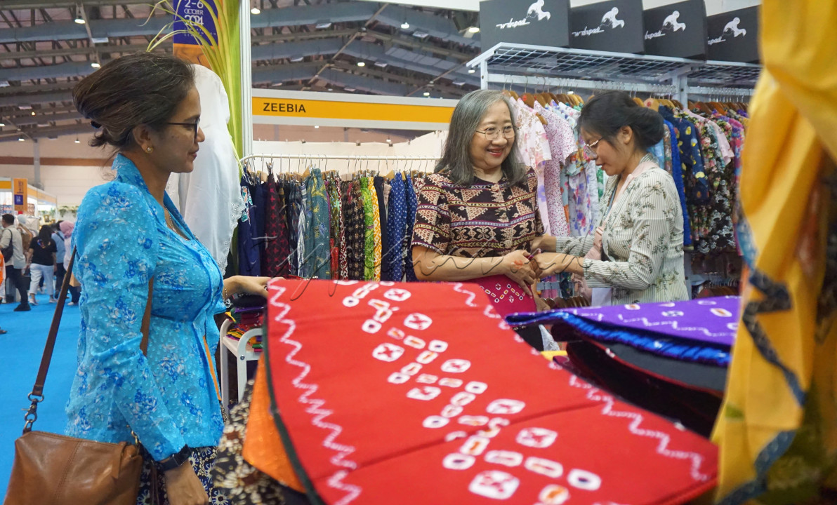 Pengunjung memilih kain batik yang ada di jual pada&nbsp;<em>The Jakarta International Handicraft Trade Fair</em>&nbsp;(Inacraft) 2024 di Jakarta Convention Center (JCC), Jakarta, Kamis (3/10/2024). Pameran diikuti 897 stan peserta sektor UMKM.