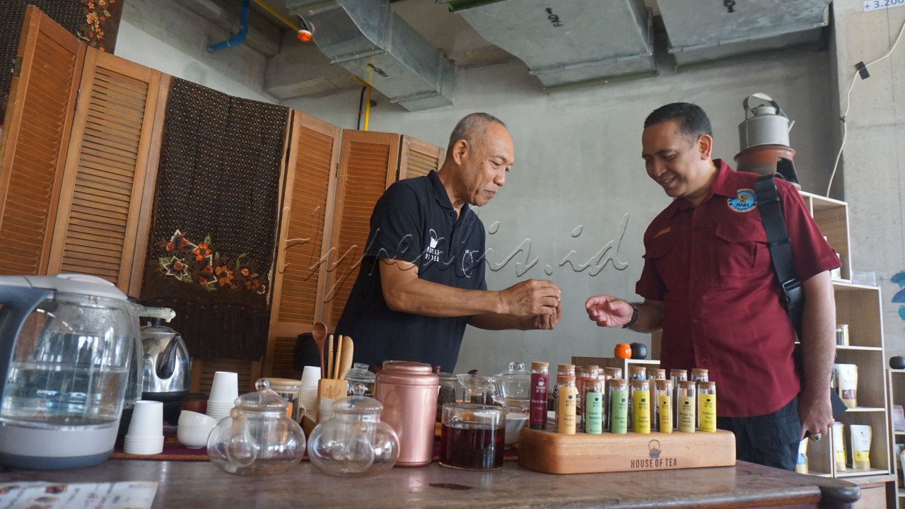 Pemilik House of Tea&nbsp;Satria Gunawan (kiri) memperlihatkan racikan teh kepada Kepala Badan Narkotika Nasional Kota Jakarta Selatan Kombes (Pol) Gazali Ahmad&nbsp;dalam acara Kenduri Teh Indonesia&nbsp;2024 Jilid 2 di&nbsp;Urban Forest, Cipete, Jakarta, Sabtu (2/10/2024).