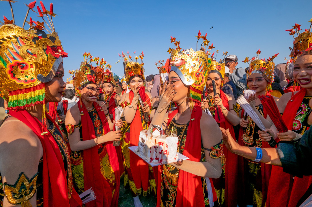 Sejumlah penari memberi kejutan kue ulang tahun ke temannya seusai mementaskan tari seribu gandrung, di Pantai Marina Boom, Banyuwangi.&nbsp;Gelaran Gandrung Sewu yang masuk dalam Kharisma Event Nusantara tersebut melibatkan 1.350 penari dengan mengangkat tema Payung Agung the Diversity of Culture yang menceritakan beragam kekayaan budaya nusantara yang hidup secara harmonis di Banyuwangi.