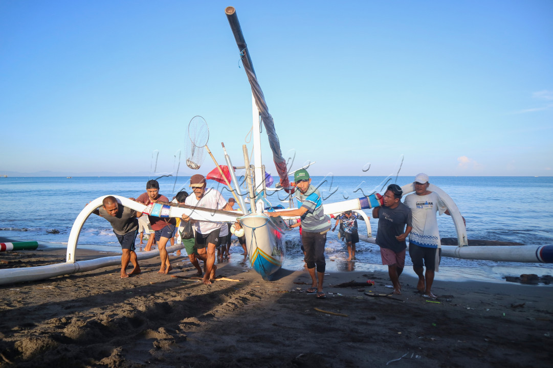 Nelayan pesisir pantai ampenan-lombok sedang bekerjasama mendorong perahu nelayan yang baru pulang dari laut dengan membawa hasil tangkapan ikan yang nantinya untuk di jual dan tentunya sebagai pendongkarak perekonomian masyarakat sekitar pesisir pantai dalam mencukupi kebutuhan hidup keluarga.&nbsp;