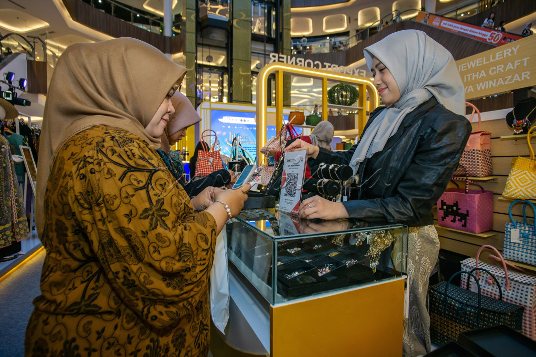 Terlihat pengunjung sedang bertransaksi dengan menggunakan sistem pembayaran Digital di sebuah stand saat pameran UMKM Karya kreatif Jawa Barat 2024, yang berlokasi di atrium Mall Trans Studio, Bandung.&nbsp;<br />
<br />
Pembayaran digital kini telah menjadi salah satu pendorong transformasi Ekonomi modern. Dengan kemudahan dan efisiensi yang ditawarkannya, sistem ini memberikan banyak dampak positif terhadap perekonomian, baik untuk individu, pelaku usaha, maupun pemerintah. Berikut adalah beberapa dampak positif pembayaran digital dalam mendorong perekonomian:<br />
1. Meningkatkan Efisiensi dan Produktivitas.<br />
Transaksi Lebih Cepat: Pembayaran digital mempercepat proses transaksi dibandingkan dengan uang tunai atau metode tradisional lainnya.<br />
Mengurangi Biaya Administrasi: Tidak perlu pencatatan manual atau pengelolaan fisik uang tunai, yang sering kali mahal dan memakan waktu.<br />
<br />
2. Meningkatkan Inklusi Keuangan<br />
Akses Keuangan untuk Semua: Pembayaran digital memungkinkan masyarakat yang tidak memiliki akses ke bank (unbanked) untuk tetap berpartisipasi dalam ekonomi formal melalui aplikasi dompet digital.<br />
Mendukung UMKM: Dengan sistem pembayaran digital, UMKM dapat menerima pembayaran dari berbagai platform, memperluas basis pelanggan mereka.<br />
<br />
3. Mendorong Transparansi Ekonomi.<br />
Pengawasan Transaksi: Semua pembayaran digital tercatat secara otomatis, sehingga mengurangi risiko korupsi, penggelapan pajak, atau aktivitas ilegal.<br />
Kepercayaan yang Lebih Tinggi: Transparansi ini meningkatkan kepercayaan konsumen terhadap pelaku usaha dan pemerintah.