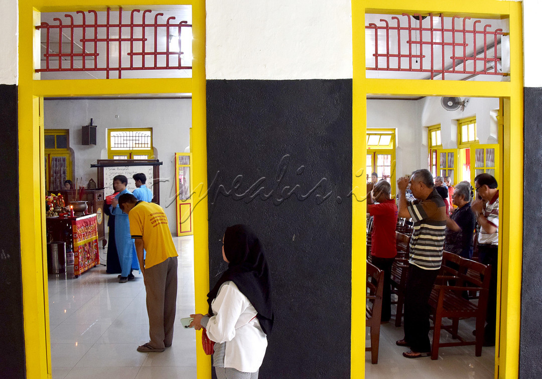 Walaupun beda pandangan, namun seorang Muslimah dengan sabar menunggu sahabatnya berdoa menurut keyakinannya di Litang Gerbang Kebajikan, satu satunya rumah ibadah umat Khonghucu, Solo.