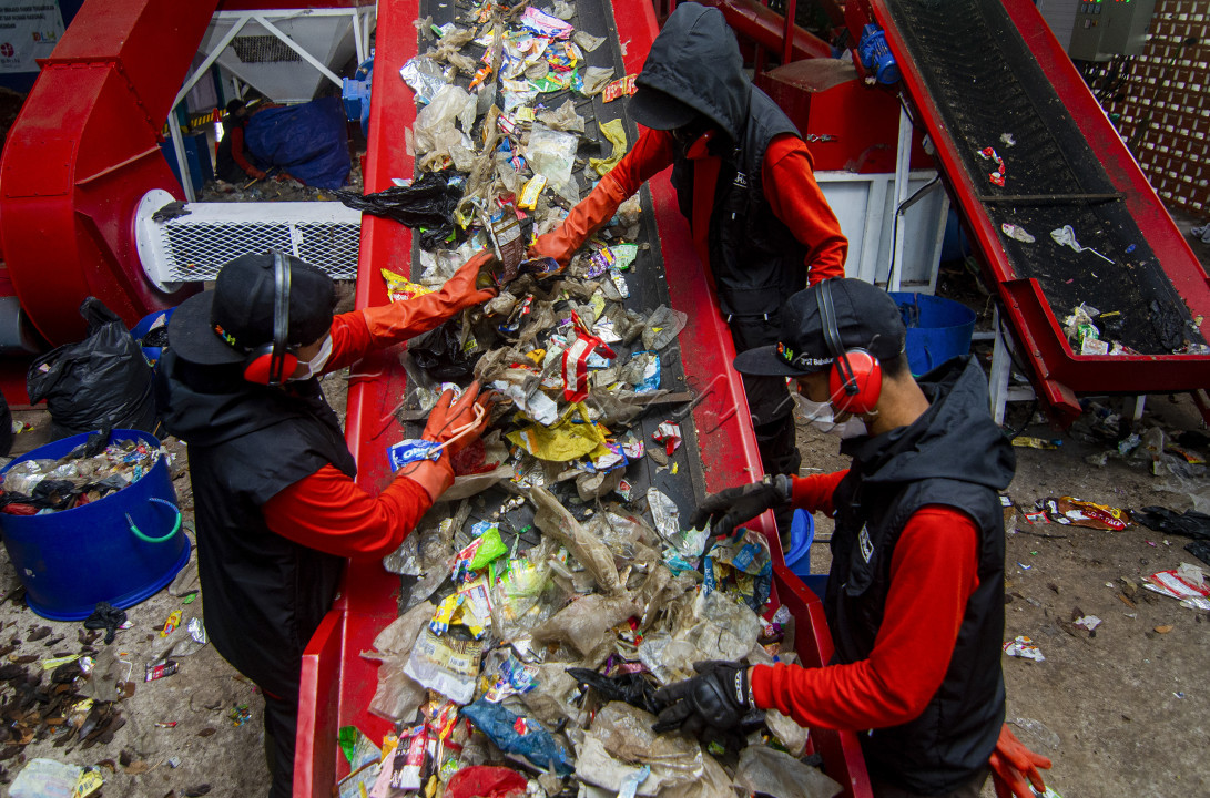 Pengolahan sampah menjadi biomassa RDF di Tempat Pembuangan Sampah Terpadu Lebak Siliwangi, Bandung, Indonesia Petugas Pengolah Sampah (Tempat Pembuangan Sampah Terpadu) TPST Babakan Siliwangi Kota Bandung sedang memasukkan sampah yang telah dipilah ke dalam mesin pencacah, untuk diolah lebih lanjut menjadi biomassa, Sabtu 15/6/2024. (tempat pembuangan sampah terpadu TPST Babakan Siliwangi saat ini telah memiliki teknologi pengolahan sampah terpadu dan terbarukan. Sampah aman dapat diolah menjadi Refuse Derived Fuel (RDF) sebagai pengganti batubara. (tempat pembuangan sampah terpadu) TPST Babakan Siliwangi dapat menghasilkan 10 ton RDF digunakan sebagai bahan bakar beberapa pabrik tekstil di sekitar Kota Bandung.