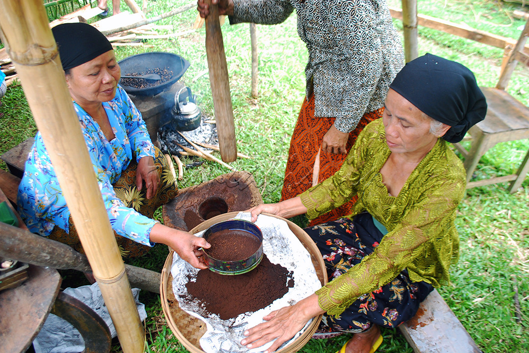 Di sudut pedesaan Jawa yang damai, tampak sekumpulan ibu-ibu lansia penuh semangat menjaga tradisi warisan leluhur. Dengan pakaian adat Jawa yang anggun&mdash;kebaya sederhana berpadu dengan jarik batik&mdash;mereka mengolah biji kopi dengan cara tradisional yang kian langka. Aroma khas biji kopi yang baru disangrai di atas tungku kayu bakar memenuhi udara, mengingatkan pada kekayaan rasa yang dihasilkan dari kesabaran dan kerja keras.<br />
Salah seorang ibu menumbuk biji kopi dalam lumpang kayu besar, irama pukulan alu bergema serasi dengan tawa mereka. Di sisi lain, seorang ibu lainnya menyaring bubuk kopi dengan penuh keahlian, memastikan butiran yang dihasilkan halus dan sempurna. Gerakan tangan yang cekatan itu bercerita tentang cinta pada budaya dan keyakinan bahwa tradisi ini adalah sumbangsih kecil namun berarti bagi negeri. Fotografi ini merangkum makna perjuangan, semangat membangun, dan melestarikan kekayaan budaya untuk generasi mendatang.