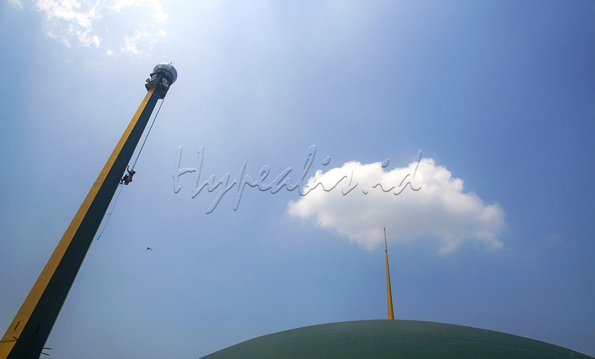 Pekerja tanpa rasa takut bergelantungan menyelesaikan pengecatan menara Masjid Al Baitul Amien Jember di Kelurahan Jember Lor, Kecamatan Patrang, Jember, Jawa Timur. Selain menjadi pusat peribadatan umat muslim di Jember, masjid ini merupakan lanskap bersejarah tidak hanya karena usianya tua, namun juga karena ada kisah partisipasi rakyat di dalamnya.
