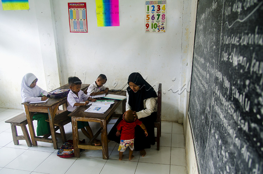 Malikatus, guru kelas satu MI (Madrasah Ibtidaiyah) Darul Ulum yang tengah mengajar sambil membawa buah hatinya yang masih balita di Dusun Sumber Canting, Desa Tugusari, Kecamatan Bangsalsari, Kabupaten Jember, Jawa Timur. Meski jumlah siswanya hanya 3 dan sekolah tempat belajar mengajar ada di kawasan pinggir hutan lereng Gunung Argopuro, dia tetap mengajar dengan penuh semangat.<br />
&nbsp;