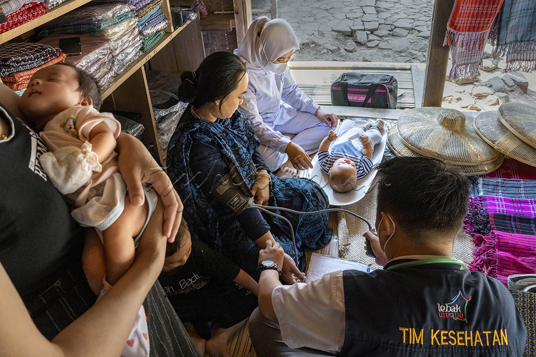 Bidan Eno beserta dokter Andri sedang melakukan pengecekan kesehatan rutin di kampung Kaduketug l, Banten. Kegiatan ini mereka lakukan satu bulan sekali, mengingat jarak tempuhnya cukup jauh.