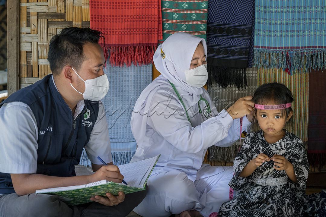 Bidan Eno beserta dokter Andri sedang melakukan pengecekan kesehatan rutin di kampung Kaduketug l, Banten. Kegiatan ini mereka lakukan satu bulan sekali, mengingat jarak tempuhnya cukup jauh.