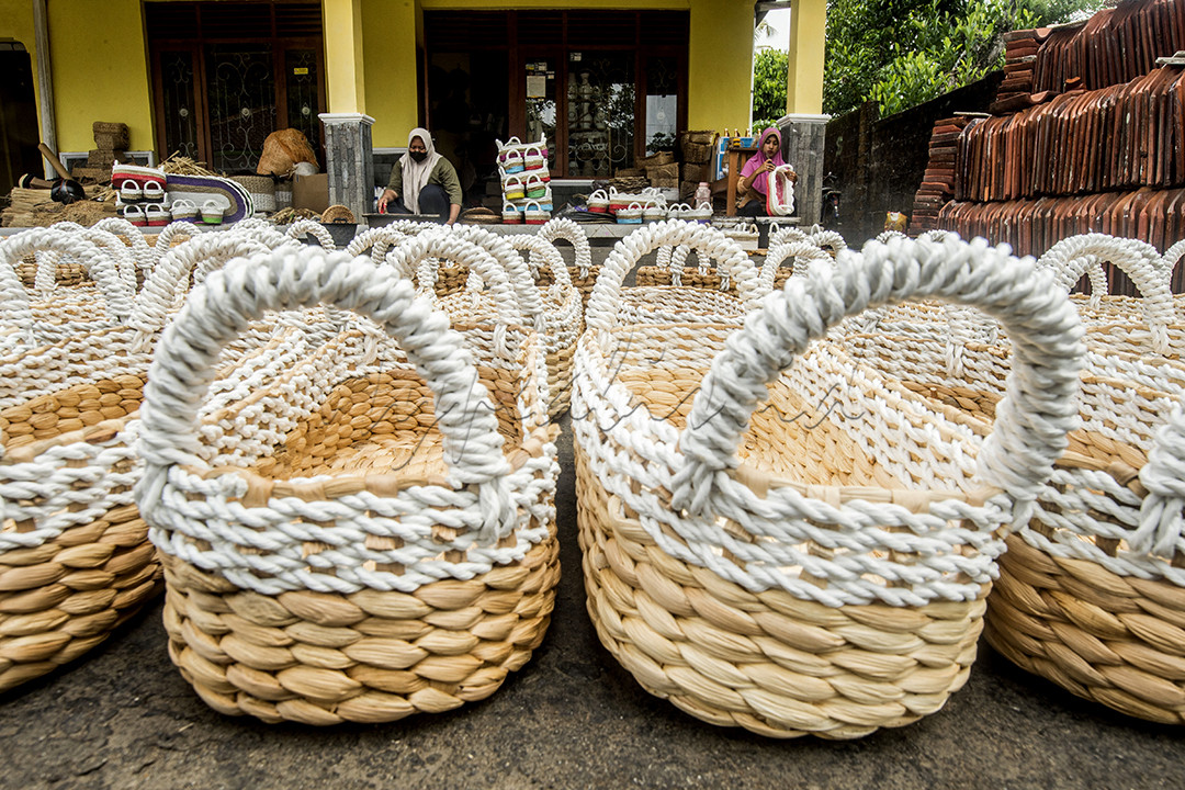 Pekerja menyelesaikan pembuatan perabot atau hiasan rumah yang berbahan baku dari pelepah pisang di rumah produksi di Moyudan, Sleman, Yogyakarta, Senin (8/1). Berbagai macam kerajian mampu dihasilkan oleh pengrajin, seperti kerangjang buah, taplak meja, vas bunga serta hiasan dinding yang dijual antara Rp 50.000 hingga Rp 300.000. Menurut para pengrajin penggunaan bahan dari pelepah pisang ini &nbsp;selain murah dan mudah didapat juga lebih mudah terurai secara alami.