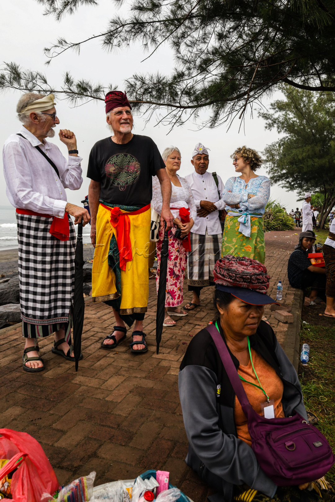Adat istiadat bali sudah di kenal sampai internasional, dan di foto ini menunjuk kan kedatangan turis yang menghargai dan dandan yang seharus nya saat ada upacara agama, dan habis itu bule tersebut membeli makanan orang yang ada di depan nya sebagai tanda di sangat menghargai apa yang ibu itu tawarkan.