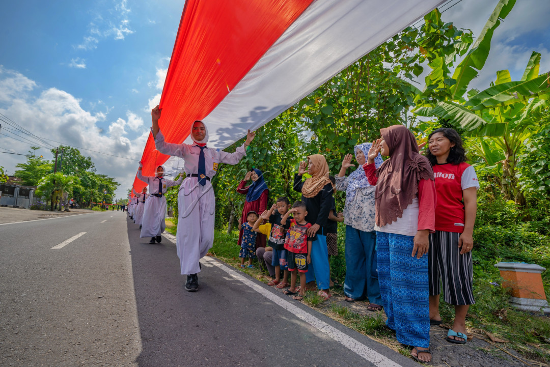 Masyarakat melakukan penghormatam kepada para Paskibraka yang mengkirab 1000 meter bendera merah putih.Pembentangan bendera merah putih sepanjang 1000 meter dalam memperingati hari Sumpah pemuda 2024 di Klaten Jawa Tengah.