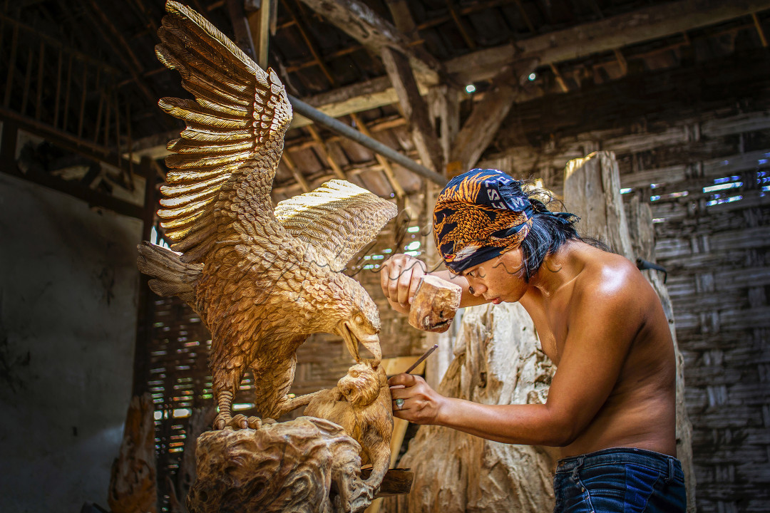 pengrajin seni ukir kayu mampu membuat patung dari kayu bekas namun memili nilai jual internasional