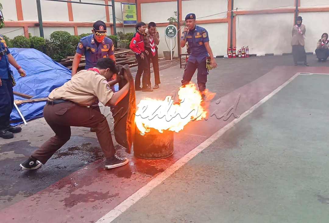 Potret seorang murid Pramuka yg berani memadamkan api, diharapkan jika terjadi di masyarakat maka anak Pramuka lah bisa membantu pencegahan dini di lain waktu&nbsp;