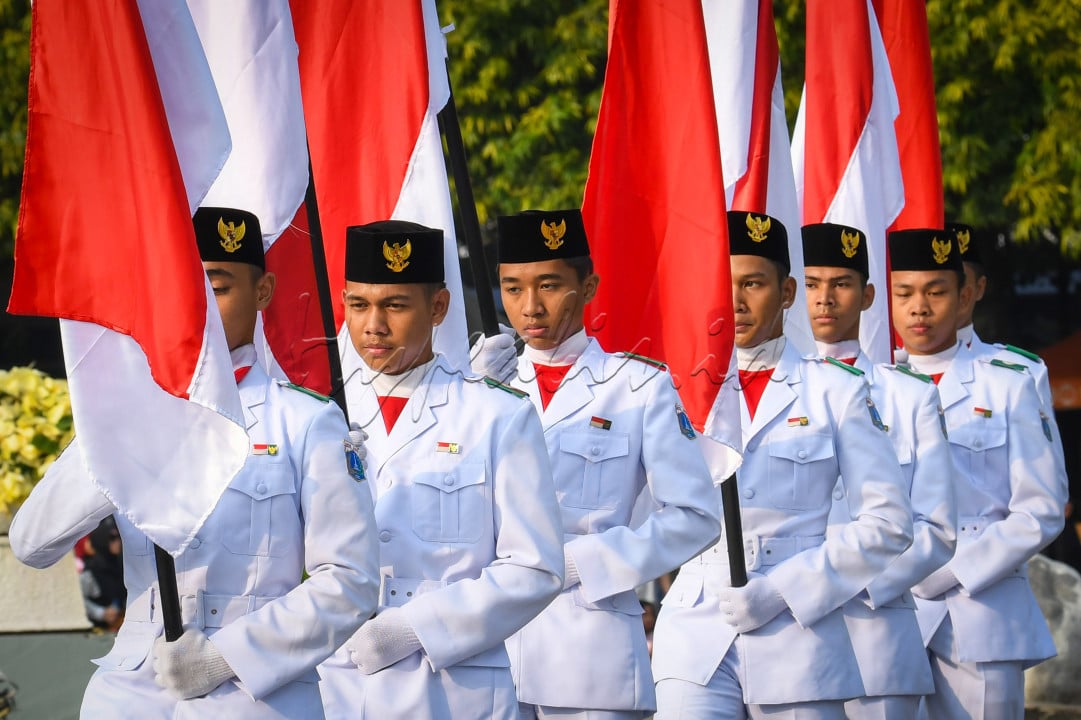 Sejumlah pasukan pengibar bendera (Paskibra) berbaris membawa bendera Merah Putih saat hari bebas kendaraan bermotor (HBKB) di Bundaran Hotel Indonesia (HI), Jakarta, Minggu (11/8/2024). Pengibaran bendera tersebut dilakukan selama Agustus sebagai bagian dari program Bulan Kebangsaan untuk menyambut HUT ke-79 Kemerdekaan Republik indonesia sekaligus meningkatkan kecintaan masyarakat terhadap Tanah Air.&nbsp;