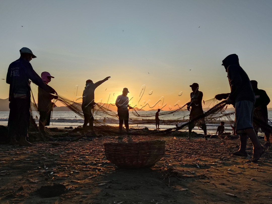 Para nelayan bersama-sama mengayunkan jaring, agar ikan kecil yang tersangkut dapat terlepas.&nbsp;