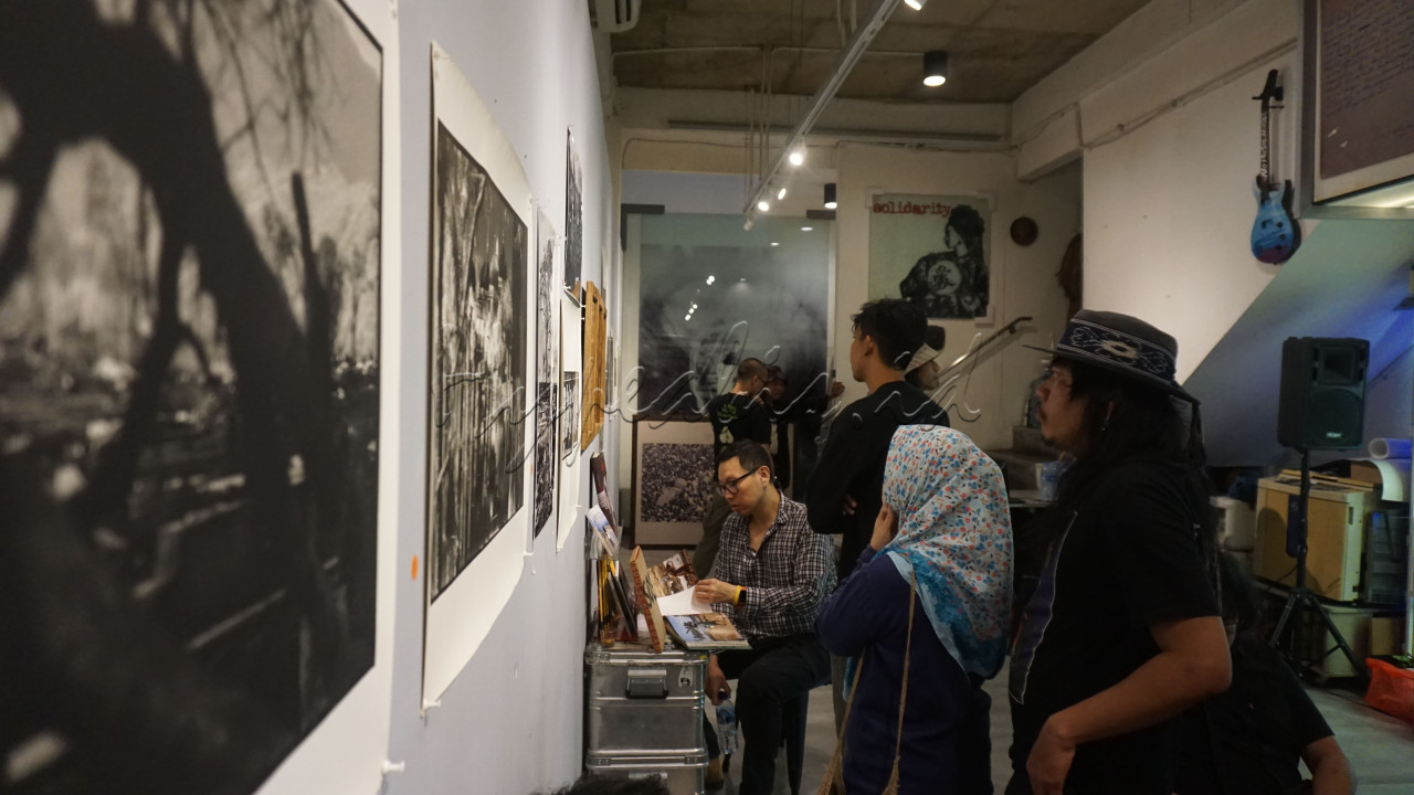 Pengunjung mengamati deretan foto tentang tsunami Aceh di Yayasan Riset Visual Mata Waktu, ITC Fatmawati, Jakarta, Kamis (26/12/2024).&nbsp;