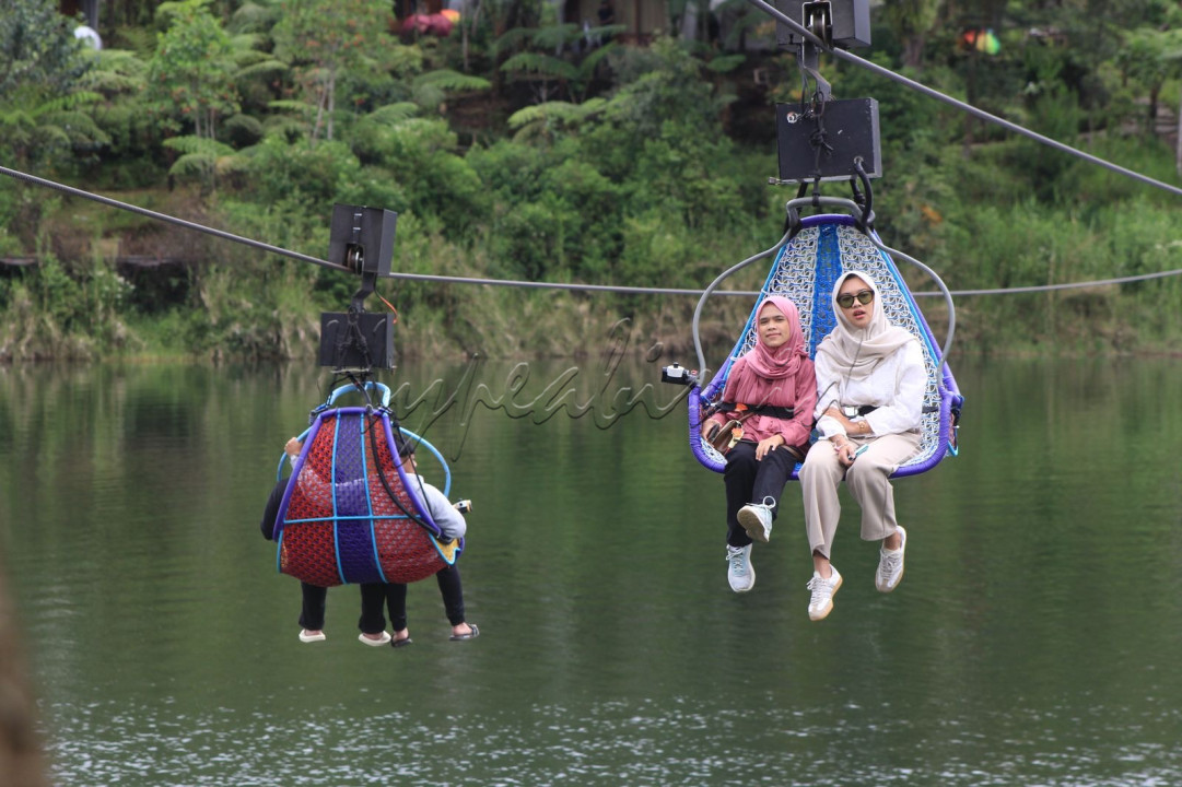 Wisatawan menaiki wahana rekreasi keranjang sultan di wisata glamping Lakesade Rancabali, Ciwidey, Kabupaten Bandung, Kamis (3/4/2025). Sebagian warga mengisi libur Lebaran dengan mengunjung berbagai tempat wisata baik di dalam maupun yang berada di luar kota.