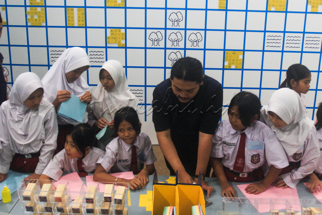 Seniman Adi Sundoro (tengah) memandu sejumlah siswa membuat karya tentang kota impiannya di Ruang Seni Anak : Gorengan Bureau di Museum Macan, Jakarta.
