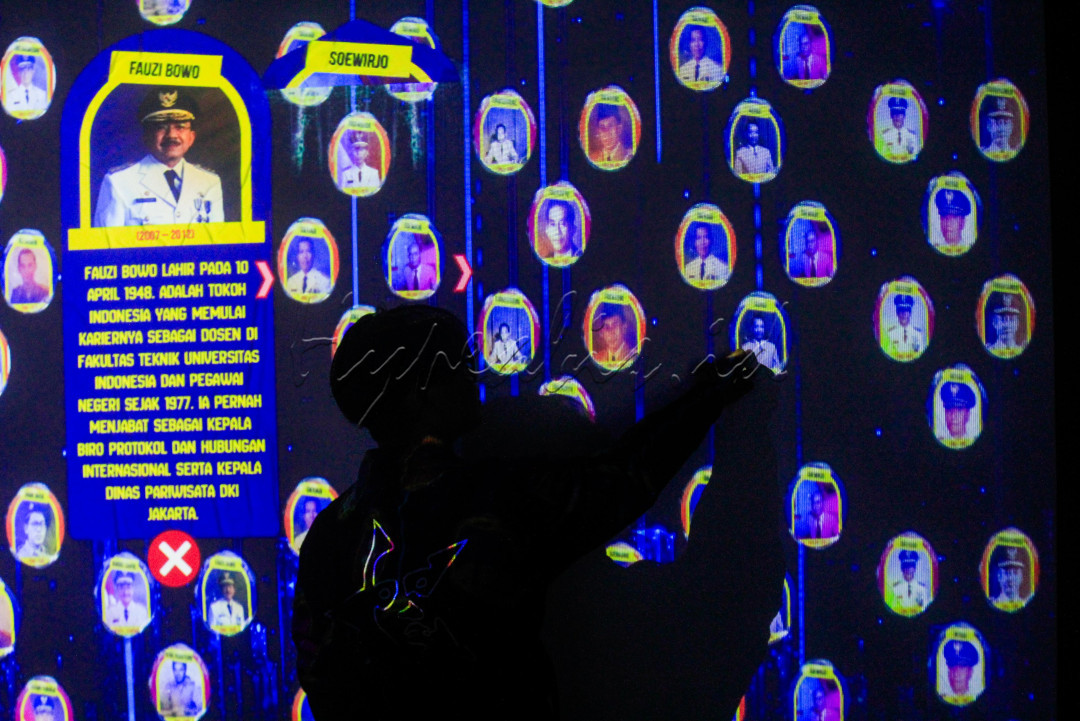 Pengunjung mengamati <em>smartwall</em> wajah gubernur dari masa ke masa di Studio Imersif Perpustakaan Jakarta dan Pusat Dokumen Sastra HB Jassin, Taman Ismail Marzuki (TIM), Jakarta, Selasa (17/6/2025). Studio imersif tersebut dibuka untuk umum secara gratis pada hari Selasa, Kamis, Sabtu, dan Minggu dengan empat sesi waktu yang bertujuan untuk memberikan layanan literasi kepada masyarakat melalui perpaduan antara teknologi digital, <em>artificial intelligence</em> (AI), arsip digital, ruang eksplorasi kreatif dan pengalaman interaktif.