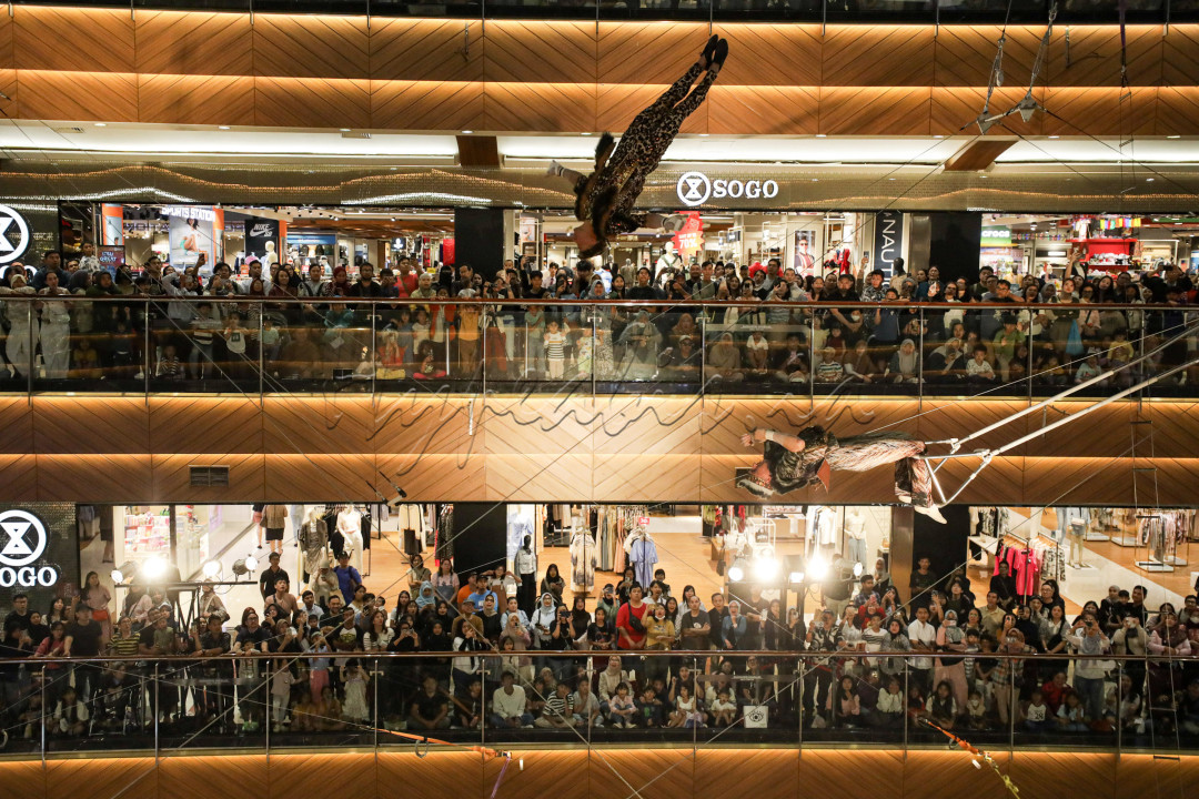 Pemain akrobatik asal Rusia tampil di Pondok Indah Mall 2, Jakarta, Jumat (20/6/2025). Pertunjukan tersebut bertajuk Flying Trapeze: Swing Into the Wilderness.