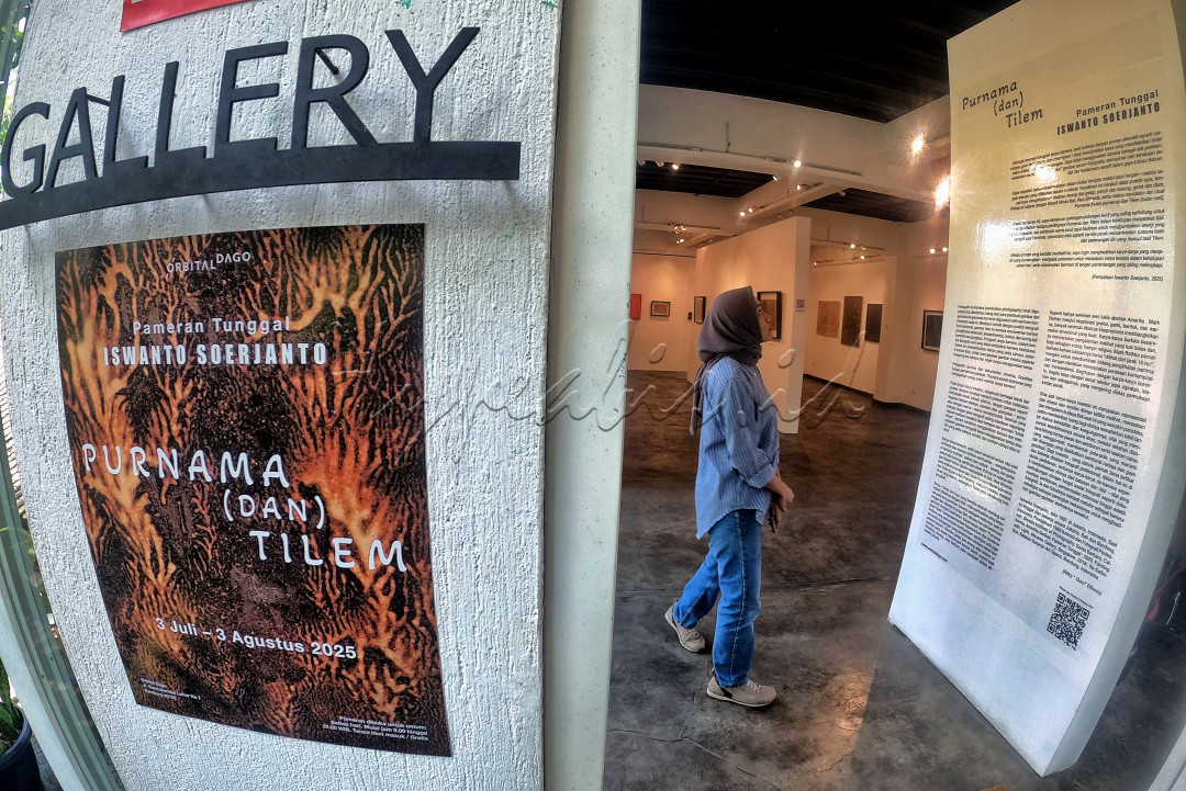 Seorang pengunjung mengamati karya milik seniman Iswanto Soerjanto yang dipamerkan di Galeri Orbital Dago, Bandung, Jawa Barat. Pameran tunggal ini mengambil tema <em>Purnama</em> (<em>dan</em>) <em>Tilem</em> atau <em>bulan mati </em>yang berlangsung hingga 3 Agustus 2025.