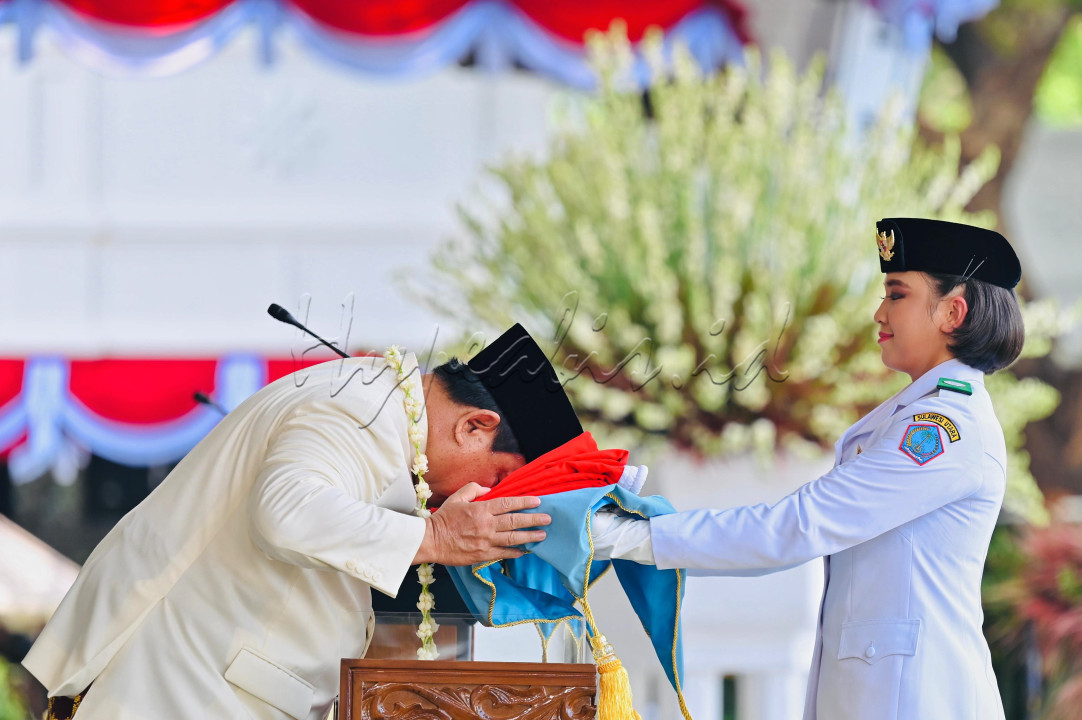 Presiden Prabowo Subianto (kiri) mencium duplikat Bendera Merah Putih saat diserahkan kepada Paskibraka pembawa baki Bianca Alessia Christabella untuk dikibarkan dalam Upacara Peringatan Detik-Detik Proklamasi Kemerdekaan ke-80 Republik Indonesia di Istana Merdeka, Jakarta, Minggu (17/8/2025). Peringatan Kemerdekaan RI tahun ini mengangkat tema <em>Bersatu, Berdaulat, Rakyat Sejahtera, Indonesia Maju.</em>&nbsp;BPMI Setpres/Laily Rachev<br />
&nbsp;