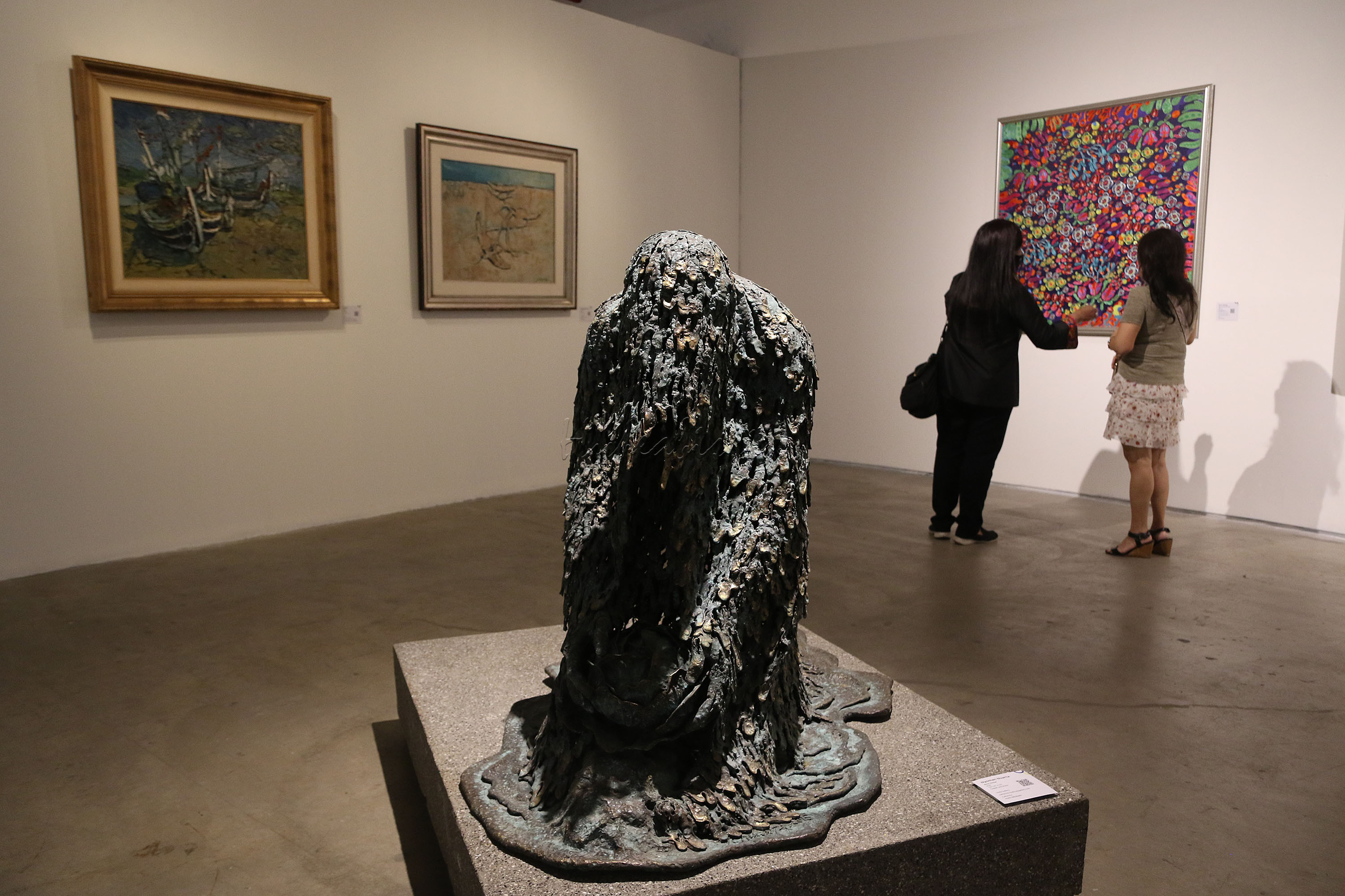 Pengunjung mengamati karya seni yang di pamerkan saat Pembukaan Art Moments Jakarta Online 2021 di Art:1 New Museum, Jakarta, Kamis (20/5/2021). Penyelenggara Art Moments Jakarta dengan bangga mengumumkan Art Moments Jakarta Online (AMJO) melalui platform virtual untuk pertama kali. Mulai tanggal 1 Juni hingga 30 Juni, pameran seni hybrid pertama di Indonesia ini dapat diakses melalui www.artmomentsjakarta.com, dan melalui aplikasi seluler Clamour. Art Moments Jakarta juga akan diadakan secara bersamaan yaitu tiga pameran offline di galeri seni ternama di Jakarta.