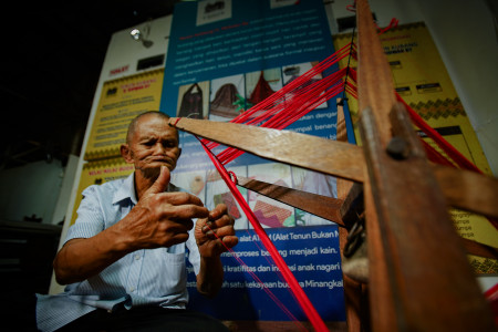 WAJAH SERIUS SEORANG BAPAK MENJALIN BENANG